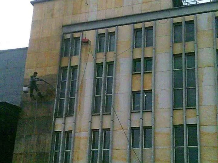 Trabajador en altura lavando la fachada de un edificio