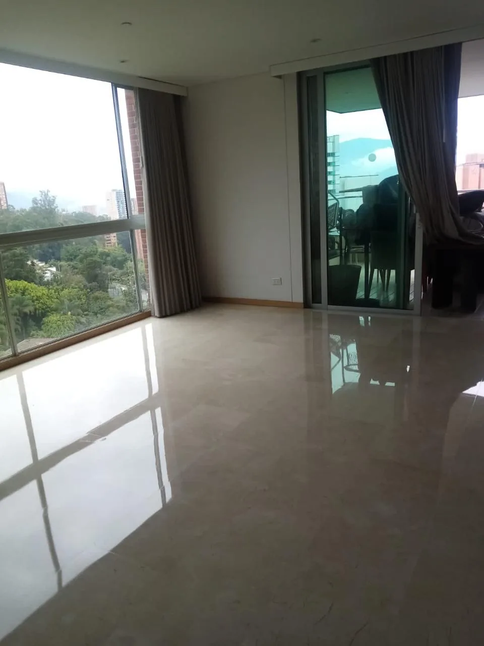 Piso de mármol pulido y brillante en una sala con ventanal